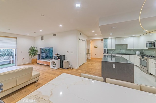4813 Oakwood Ave Unit 201, Los Angeles, CA 90004 - kitchen with stainless steel appliances, modern cabinets, white cabinets, recessed lighting, and decorative backsplash