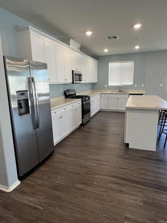 32323 Roman Warren Way, Winchester, CA 92596 - kitchen featuring appliances with stainless steel finishes, a sink, dark wood-type flooring, white cabinetry, and light countertops