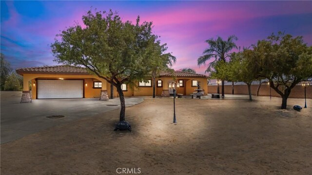 5071 Bushnell Ave, Riverside, CA 92505 - view of front of house featuring a garage, a tiled roof, concrete driveway, and stucco siding