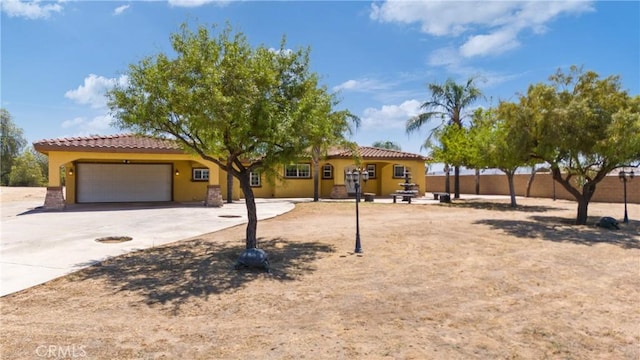 5071 Bushnell Ave, Riverside, CA 92505 - mediterranean / spanish home with a tiled roof, stucco siding, a garage, and driveway
