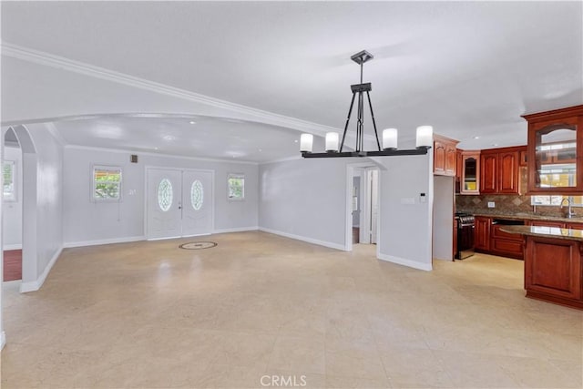5071 Bushnell Ave, Riverside, CA 92505 - unfurnished living room featuring arched walkways, crown molding, and a chandelier