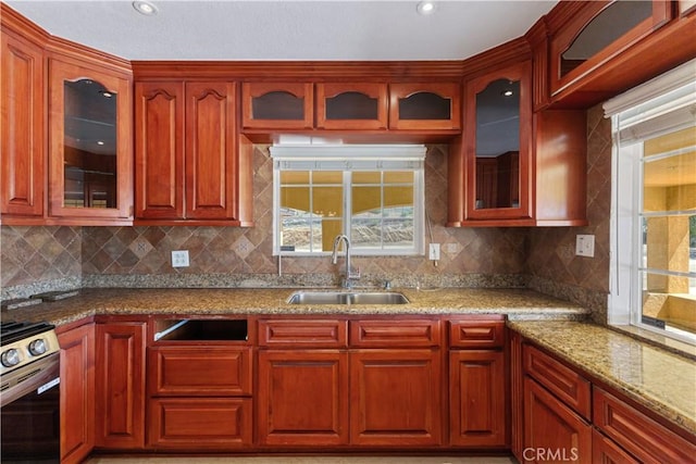 5071 Bushnell Ave, Riverside, CA 92505 - kitchen featuring stainless steel gas range, light stone counters, tasteful backsplash, glass insert cabinets, and dark brown cabinets
