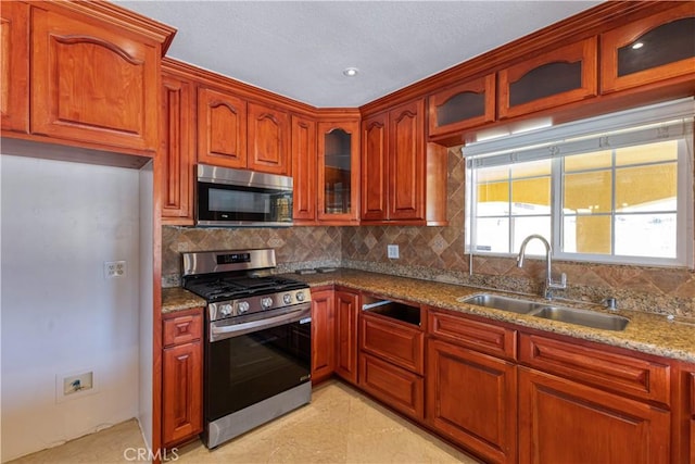 5071 Bushnell Ave, Riverside, CA 92505 - kitchen featuring stainless steel appliances, backsplash, light stone counters, and glass insert cabinets