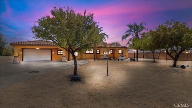 5071 Bushnell Ave, Riverside, CA 92505 - view of front facade featuring a tile roof, a garage, driveway, and stucco siding
