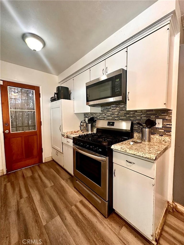 3346 Sunnyside Dr, Riverside, CA 92506 - kitchen with appliances with stainless steel finishes, light wood finished floors, tasteful backsplash, white cabinetry, and baseboards