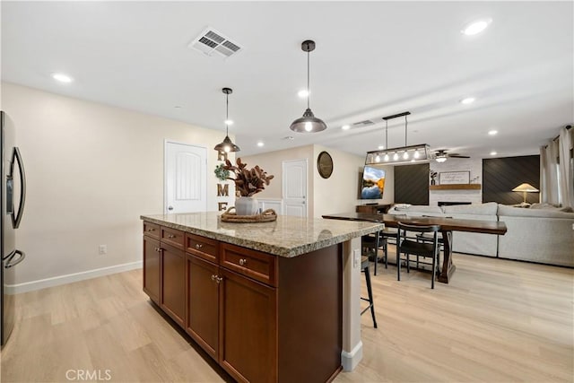 29377 Wyatt Earp Way, Winchester, CA 92596 - kitchen featuring light wood finished floors, ceiling fan, pendant lighting, recessed lighting, and light stone counters