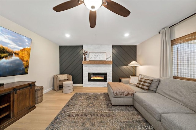 29377 Wyatt Earp Way, Winchester, CA 92596 - living area featuring an accent wall, wood finished floors, a large fireplace, baseboards, and ceiling fan
