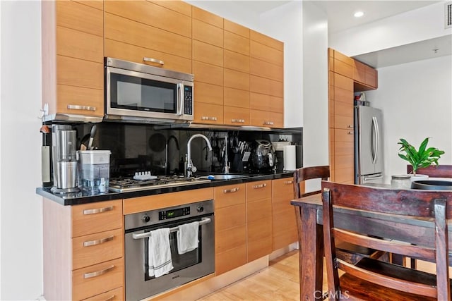460 S Spring St Unit 613, Los Angeles, CA 90013 - kitchen featuring appliances with stainless steel finishes, decorative backsplash, dark countertops, modern cabinets, and a sink
