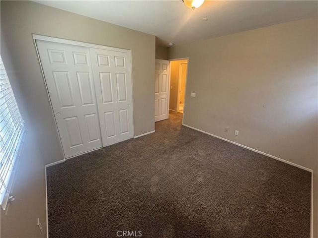 9757 Edenbrook Dr, Riverside, CA 92503 - unfurnished bedroom with dark carpet, baseboards, and a closet