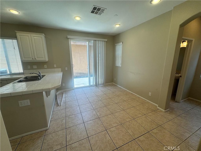 9757 Edenbrook Dr, Riverside, CA 92503 - unfurnished dining area with a sink, arched walkways, light tile patterned floors, recessed lighting, and baseboards