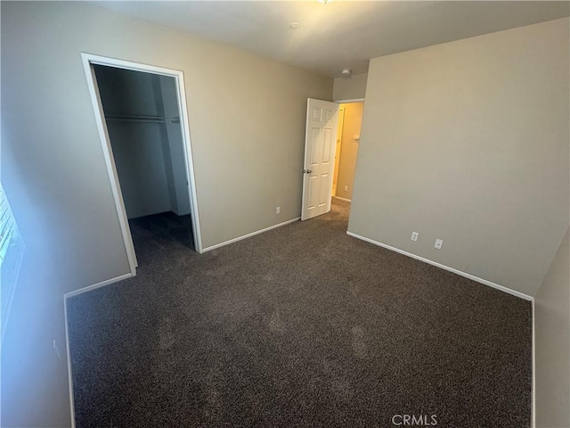 9757 Edenbrook Dr, Riverside, CA 92503 - unfurnished bedroom with baseboards, dark colored carpet, a spacious closet, and a closet
