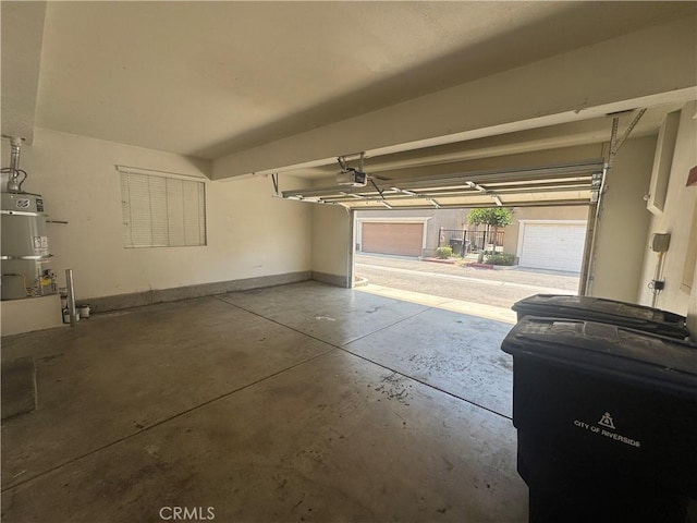 9757 Edenbrook Dr, Riverside, CA 92503 - garage with a garage door opener, strapped water heater, and baseboards