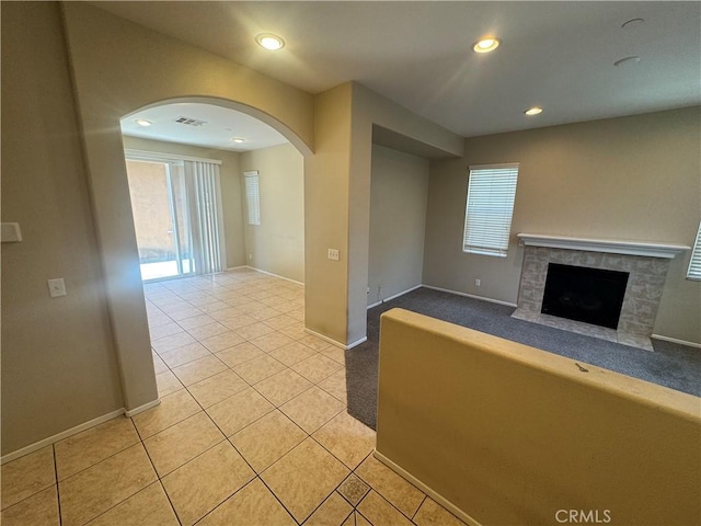 9757 Edenbrook Dr, Riverside, CA 92503 - unfurnished living room with baseboards, arched walkways, light tile patterned flooring, a tile fireplace, and recessed lighting