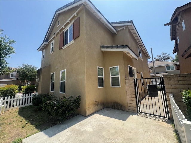 9757 Edenbrook Dr, Riverside, CA 92503 - view of side of home featuring stucco siding, a gate, and a patio