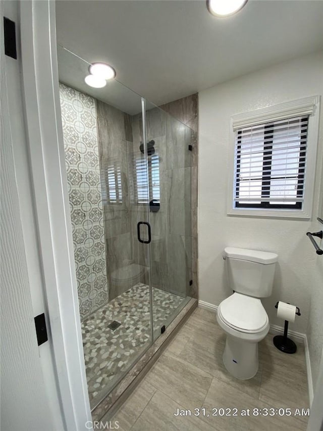 20515 Bushton Pl, Perris, CA 92570 - bathroom with toilet, baseboards, healthy amount of natural light, and a shower stall
