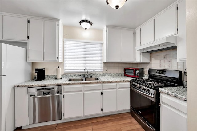 507 W La Jolla St, Placentia, CA 92870 - kitchen with appliances with stainless steel finishes, under cabinet range hood, light countertops, backsplash, and white cabinets
