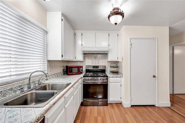 507 W La Jolla St, Placentia, CA 92870 - kitchen with stainless steel gas range, under cabinet range hood, light wood finished floors, and white cabinets