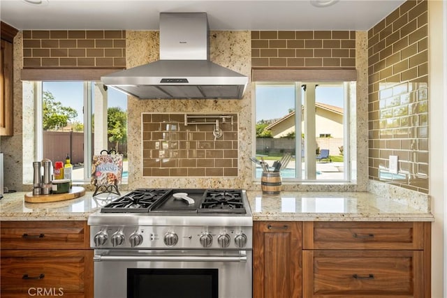 6021 Saddletree Ln, Yorba Linda, CA 92886 - kitchen featuring high end stove, wall chimney range hood, brown cabinetry, and healthy amount of natural light