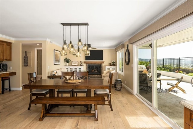 6021 Saddletree Ln, Yorba Linda, CA 92886 - dining area with ornamental molding, light wood finished floors, and a warm lit fireplace
