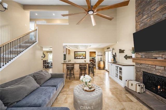 6021 Saddletree Ln, Yorba Linda, CA 92886 - living room featuring a ceiling fan, a towering ceiling, a stone fireplace, plenty of natural light, and stairs