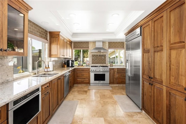 6021 Saddletree Ln, Yorba Linda, CA 92886 - kitchen featuring high quality appliances, wall chimney exhaust hood, crown molding, backsplash, and brown cabinets