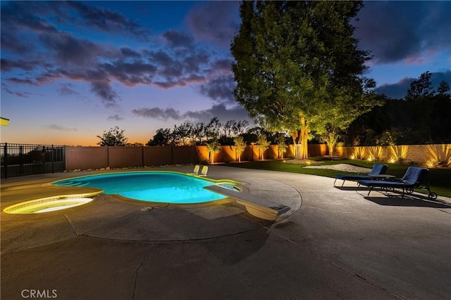6021 Saddletree Ln, Yorba Linda, CA 92886 - pool at dusk featuring a fenced backyard, a patio, an in-ground hot tub, and a diving board