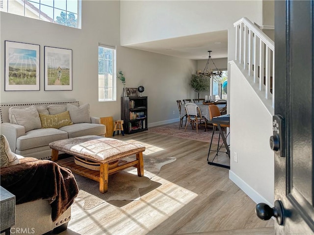 795 Donatello Dr, Corona, CA 92882 - living room with stairway, light wood-style floors, a chandelier, and a towering ceiling