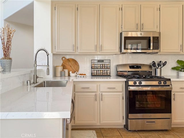 795 Donatello Dr, Corona, CA 92882 - kitchen featuring stainless steel appliances, cream cabinetry, decorative backsplash, and light stone countertops