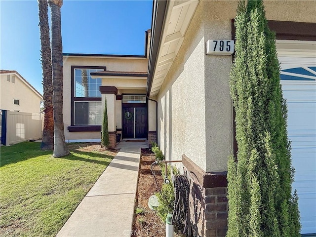 795 Donatello Dr, Corona, CA 92882 - view of exterior entry with a lawn and stucco siding