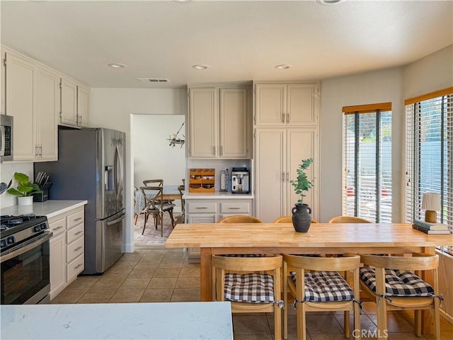 795 Donatello Dr, Corona, CA 92882 - kitchen with appliances with stainless steel finishes, light countertops, light tile patterned floors, recessed lighting, and white cabinets