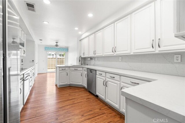 24545 Santa Clara Ave, Dana Point, CA 92629 - kitchen featuring appliances with stainless steel finishes, white cabinetry, a peninsula, wood finished floors, and recessed lighting