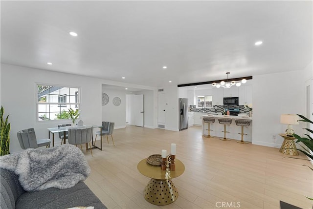 17121 Simonds St, Granada Hills, CA 91344 - living area featuring a chandelier, recessed lighting, light wood-style floors, and baseboards