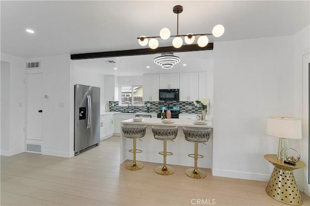 17121 Simonds St, Granada Hills, CA 91344 - kitchen featuring black microwave, stainless steel refrigerator with ice dispenser, stove, backsplash, and light countertops
