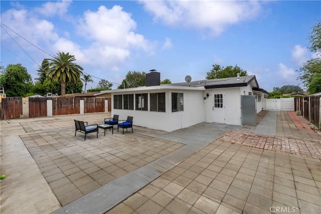 17121 Simonds St, Granada Hills, CA 91344 - rear view of house featuring a patio, a fenced backyard, a chimney, a sunroom, and stucco siding