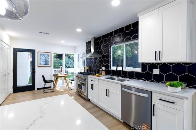 12009 Dresden Pl, Granada Hills, CA 91344 - kitchen with appliances with stainless steel finishes, a sink, wall chimney exhaust hood, recessed lighting, and light wood-style floors
