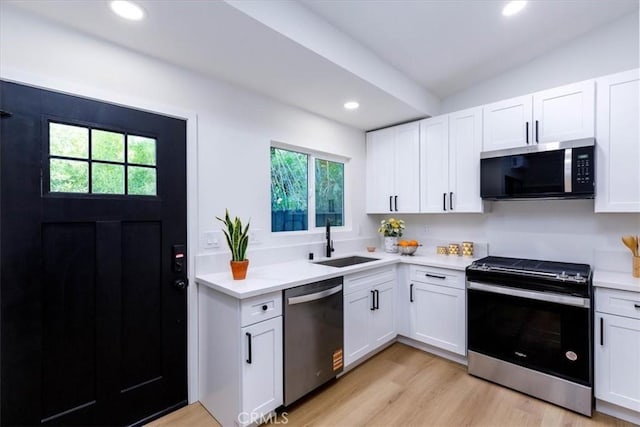 12009 Dresden Pl, Granada Hills, CA 91344 - kitchen with appliances with stainless steel finishes, a sink, light countertops, recessed lighting, and white cabinetry