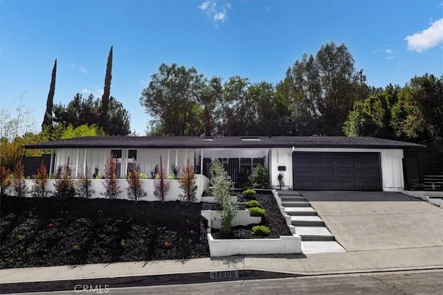 12009 Dresden Pl, Granada Hills, CA 91344 - view of front of home featuring an attached garage, driveway, and board and batten siding