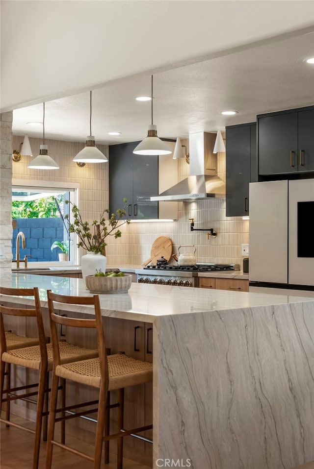 19851 Malaga Ln, Yorba Linda, CA 92886 - kitchen featuring wall chimney exhaust hood, stainless steel gas cooktop, freestanding refrigerator, backsplash, and light stone counters