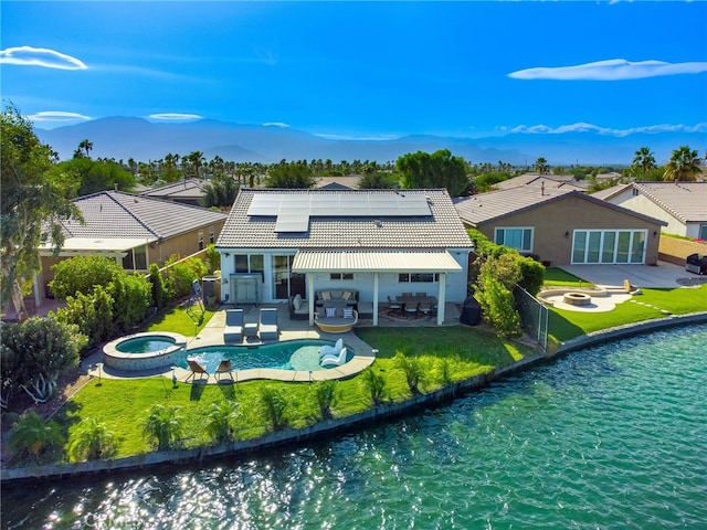 84290 Tramonto Way, Indio, CA 92203 - back of house featuring a tiled roof, outdoor lounge area, roof mounted solar panels, a mountain view, and a patio area