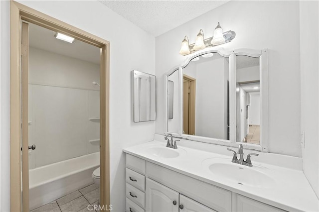 18620 Hatteras St Unit 274, Tarzana, CA 91356 - bathroom with double vanity, toilet, a textured ceiling, tile patterned flooring, and washtub / shower combination