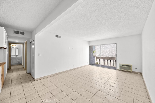 18620 Hatteras St Unit 274, Tarzana, CA 91356 - unfurnished room with a textured ceiling, a wall unit AC, light tile patterned floors, and baseboards