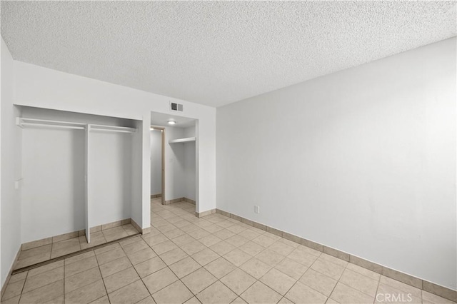 18620 Hatteras St Unit 274, Tarzana, CA 91356 - unfurnished bedroom featuring a closet, a textured ceiling, light tile patterned flooring, and baseboards