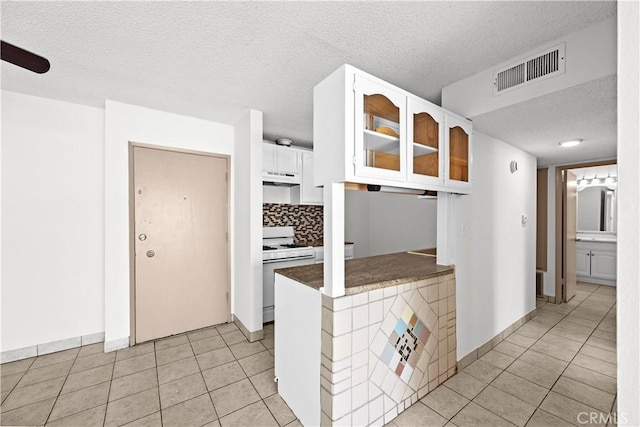 18620 Hatteras St Unit 274, Tarzana, CA 91356 - kitchen featuring gas range gas stove, under cabinet range hood, a textured ceiling, white cabinetry, and light tile patterned floors