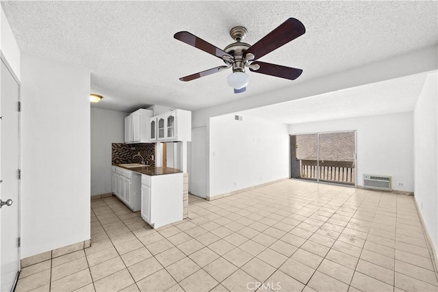 18620 Hatteras St Unit 274, Tarzana, CA 91356 - kitchen featuring dark countertops, tasteful backsplash, a sink, a ceiling fan, and white cabinetry