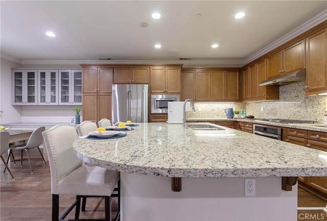 1123 Klose Ln, Fullerton, CA 92833 - kitchen featuring appliances with stainless steel finishes, under cabinet range hood, a sink, ornamental molding, and a kitchen bar