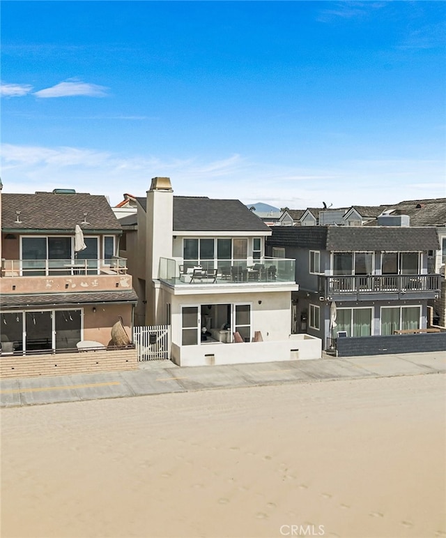 3012 W Oceanfront, Newport Beach, CA 92663 - rear view of house with a balcony and stucco siding