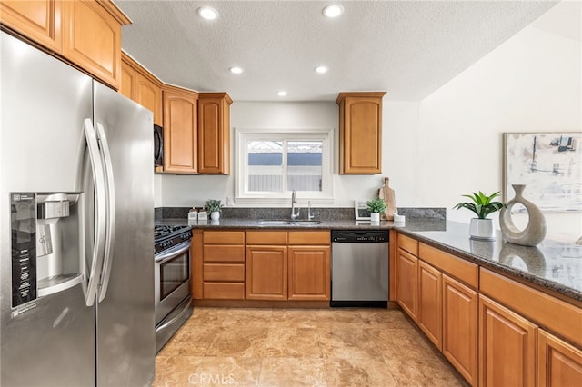 3012 W Oceanfront, Newport Beach, CA 92663 - kitchen featuring appliances with stainless steel finishes, dark stone countertops, brown cabinets, a textured ceiling, and recessed lighting