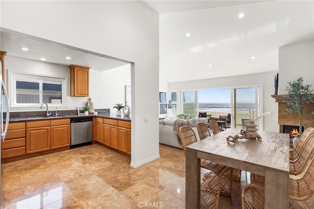 3012 W Oceanfront, Newport Beach, CA 92663 - kitchen featuring dishwasher, dark countertops, a towering ceiling, recessed lighting, and a warm lit fireplace