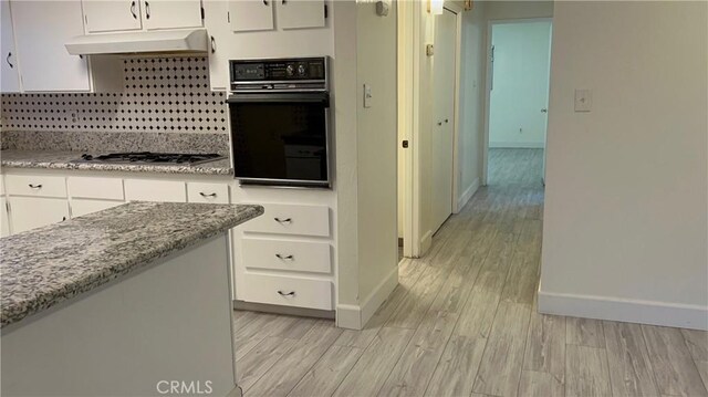 2605 Auburn Ct, Bakersfield, CA 93306 - kitchen with oven, baseboards, white cabinetry, and light wood-style floors