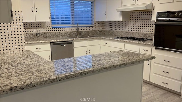 2605 Auburn Ct, Bakersfield, CA 93306 - kitchen featuring dishwasher, black oven, a sink, white cabinets, and tasteful backsplash